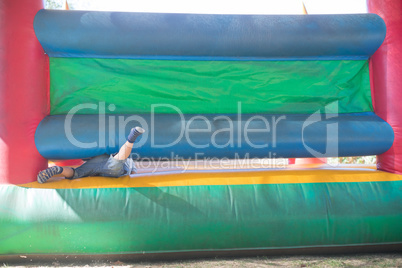 Low section of boy playing on bouncy castle