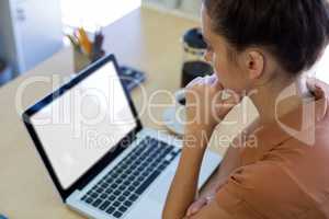 Female executive working over laptop at her desk