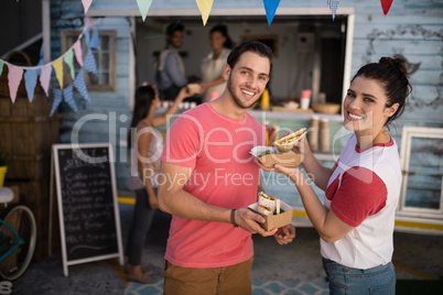 Smiling couple standing with snacks