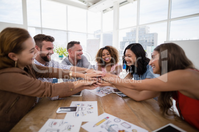 Team of executives forming hand stack in the office