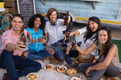 Group of friends cheering with beer bottles