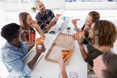 Group of executives interacting while having pizza