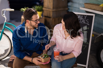 Couple interacting while having snacks and juice