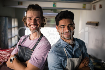 Portrait of confident waiters standing with arms crossed