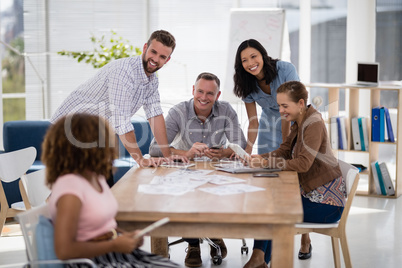 Team of executives interacting with each other while working in the office