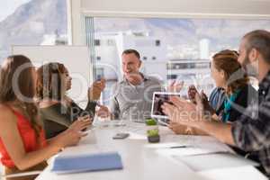 Colleagues applauding man while presentation