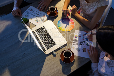 Executives discussing over laptop during a meeting