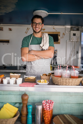 Portrait of waiter standing with arms crossed