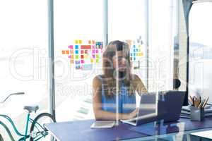 Female executive working over laptop