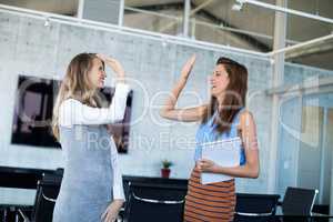 Female executives giving high five