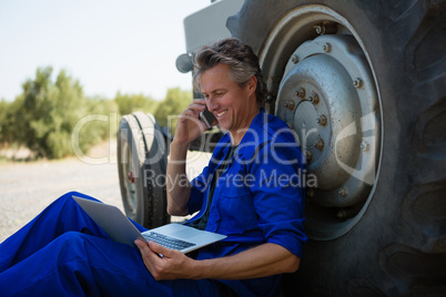 Worker talking on mobile phone while using laptop