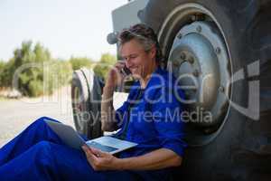 Worker talking on mobile phone while using laptop