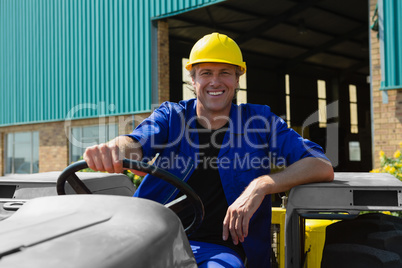 Smiling worker sitting in tractor