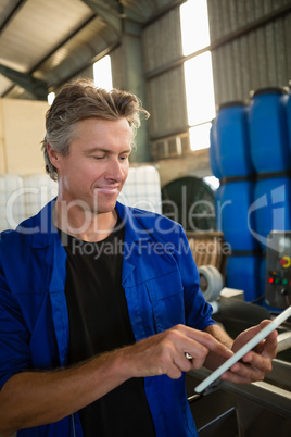 Worker using digital tablet in factory