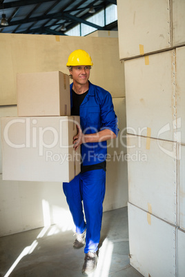 Worker holding a cardboard boxes while walking