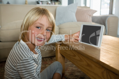 Boy using digital tablet in the living room at home Boy using digital tablet in the living room at home