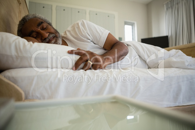 Senior man sleeping on bed in the bedroom