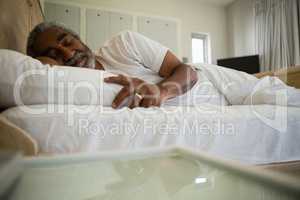 Senior man sleeping on bed in the bedroom