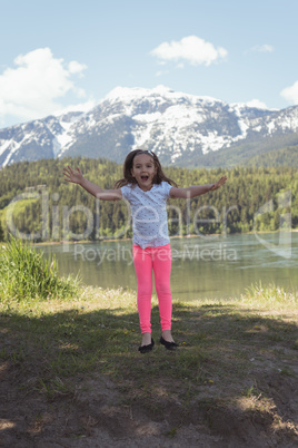 Portrait of cute girl jumping near river