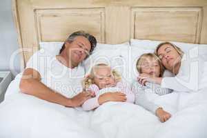 Family sleeping on bed in the bed room