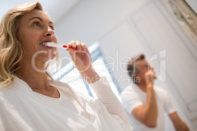Couple brushing teeth in bathroom