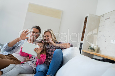 Family having a video call on digital tablet in living room