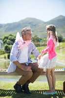 Daughter and father in fairy costume interacting with each other