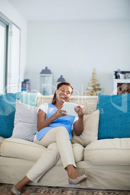 Smiling woman using digital tablet in living room