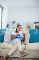 Smiling woman using digital tablet in living room