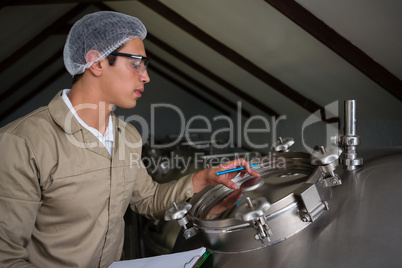 Worker examining storage tank