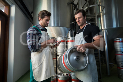 Workers examining kegs