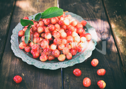 Ripe red cherry in an iron plate