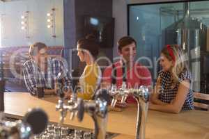 Friends talking at bar counter