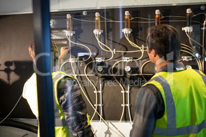 Workers examining pressure gauge