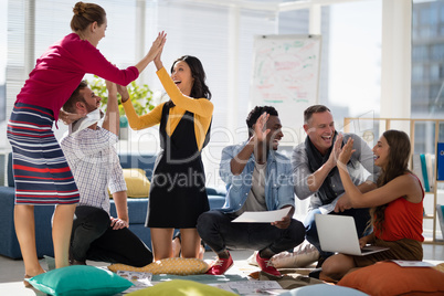 Business colleagues giving high five to each other