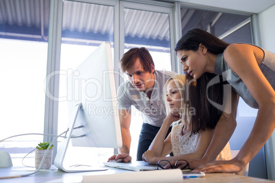 Executives discussing over computer during a meeting