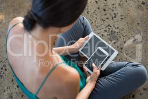 Female executive using digital tablet and mobile phone in office