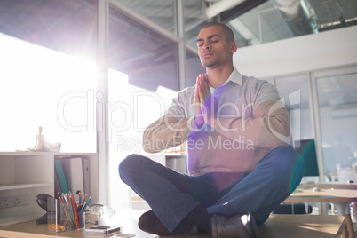 Male executive doing yoga in office