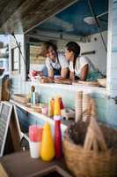 Waiter and waitress interacting with each other at counter