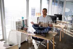 Male executive doing yoga in office