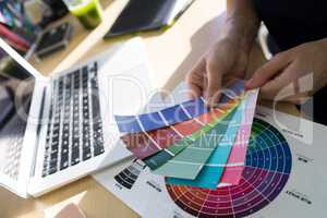 Female executives holding color shade swatch at her desk