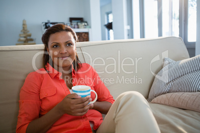 Woman having coffee in the living room at home
