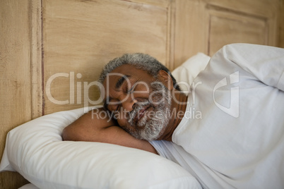 Senior man sleeping on bed in the bedroom