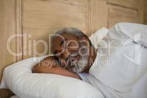 Senior man sleeping on bed in the bedroom