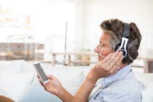 Man listening to music on headphones in living room