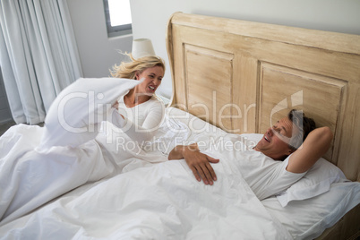 Woman getting irritated while man snoring on bed
