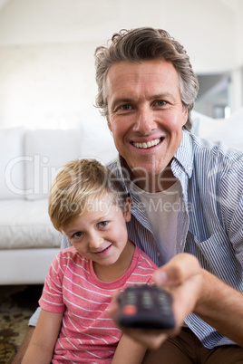 Father and son watching television in living room