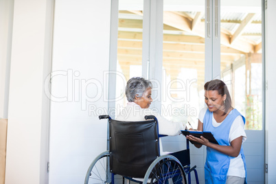 Disability senior woman discussing with female doctor