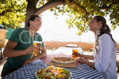 Happy friends enjoying beer at outdoor restaurant