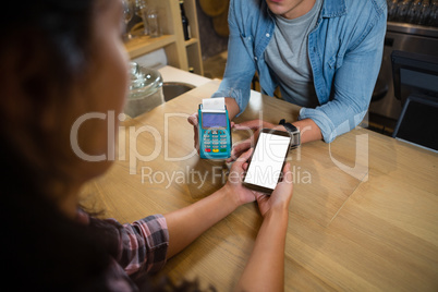 Midsection of man making payment at bar